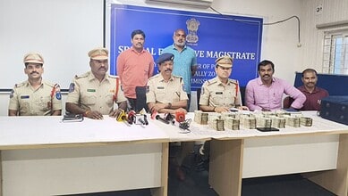 Hyderabad police arrest ATM van driver involved in Rs 56 lakh theft, with officers displaying seized cash.