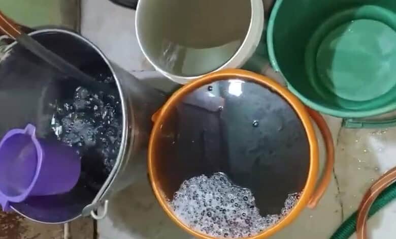 Buckets of polluted water in Warsiguda highlight health risks from contaminated drinking water.