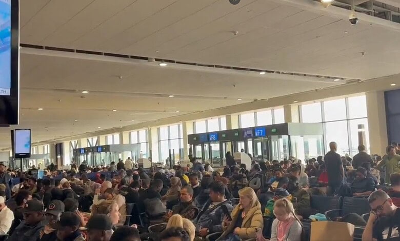Crowded airport terminal with travelers waiting, reflecting busy travel conditions amid ongoing geopoliti.