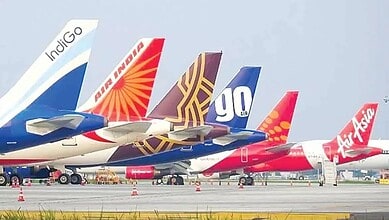 Several commercial airplanes parked on the tarmac with airline logos visible, amid advisories to avoid ce.