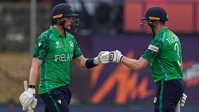 Irish cricket players Lorcan Tucker and teammate fist bump during match against Oman.