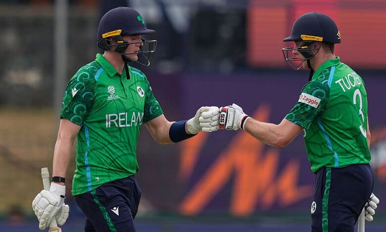 Irish cricket players Lorcan Tucker and teammate fist bump during match against Oman.