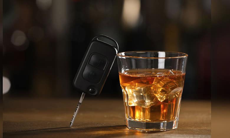 Image shows a car key and a glass of whiskey, emphasizing the crackdown on drunk driving by Hyderabad traffic police.