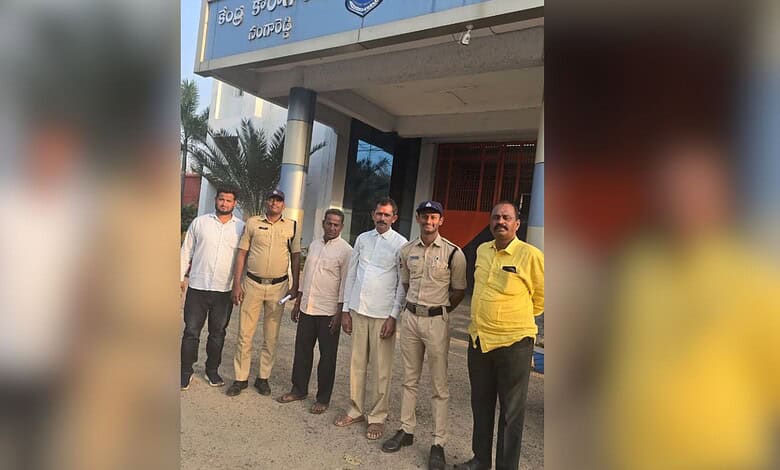 Group of men and police officers outside a government building in India.