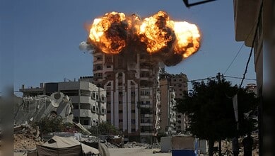 Explosion in Gaza building during conflict, highlighting the devastation faced by civilians.