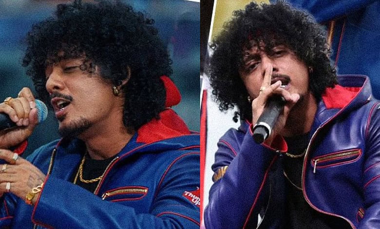 Hanumankind singing into a microphone during a live performance.