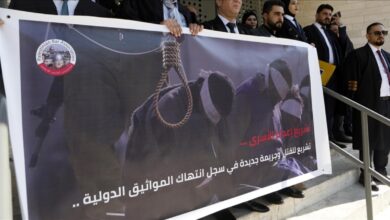 Lawyers in Hebron hold a banner depicting a noose and blindfolded detainees during a protest against a proposed death penalty law.