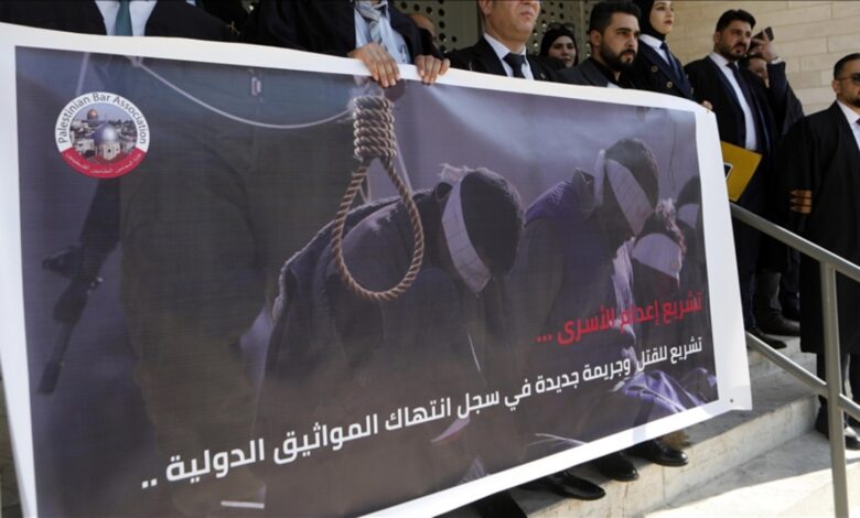 Lawyers in Hebron hold a banner depicting a noose and blindfolded detainees during a protest against a proposed death penalty law.
