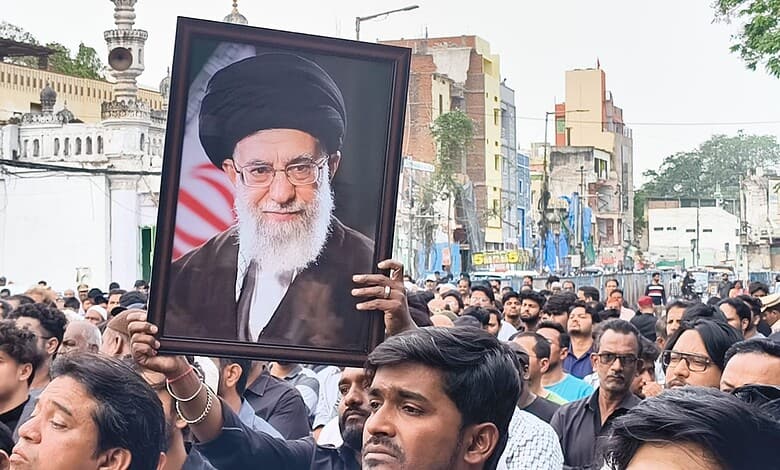A protester holds a portrait of Ayatollah Ali Khamenei during a rally in Hyderabad following reports of his death.