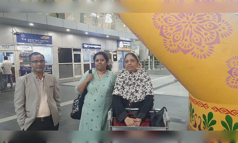 Indian woman with family at airport after reunion, smiling and happy to be back home.
