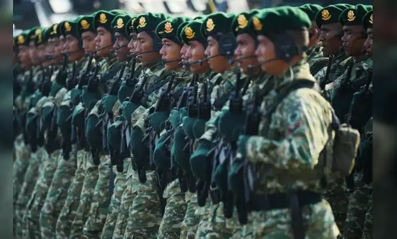Indonesian soldiers in green berets march in formation during a military ceremony in Jakarta.