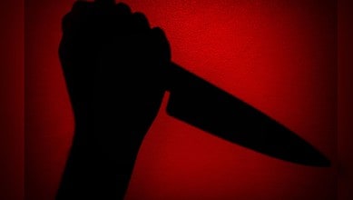 Image shows A dramatic silhouette of a hand gripping a knife against a glowing red background,