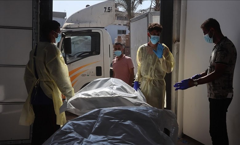 Medical team handling a body on a stretcher at a hospital or morgue.