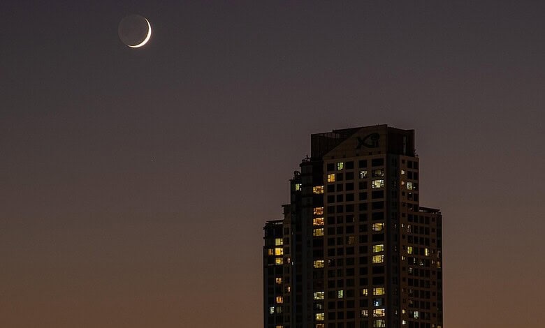 Crescent moon over Hyderabad skyline during Ramzan moon sighting meeting.