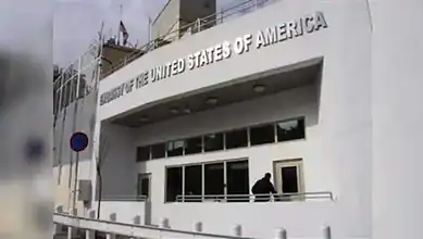 US Embassy in Syria building with American flag and signage.