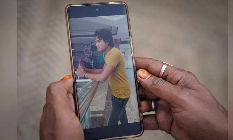 Woman with yellow shirt using smartphone at train station platform.