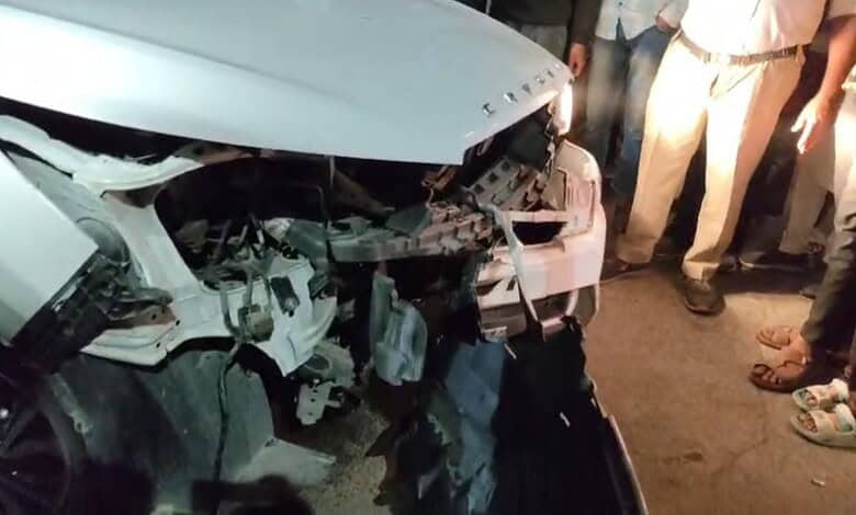 Damaged white car after collision with divider in Hyderabad's Bahadurpura, injuring four.
