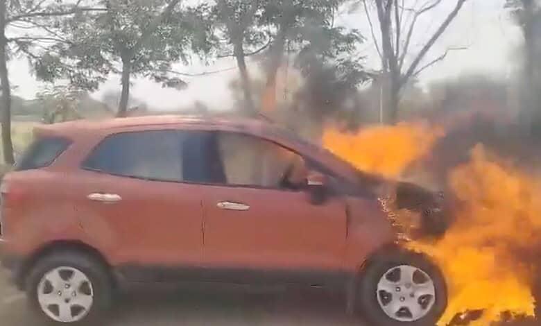 Car on fire during an accident, with flames and smoke.