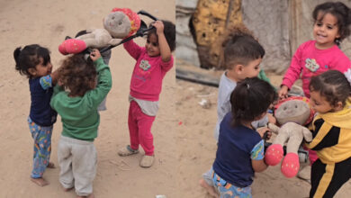 Children in Gaza act out a funeral scene while they play with dolls