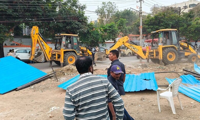 Workers and machinery demolish blue fencing on government land in Attapur.