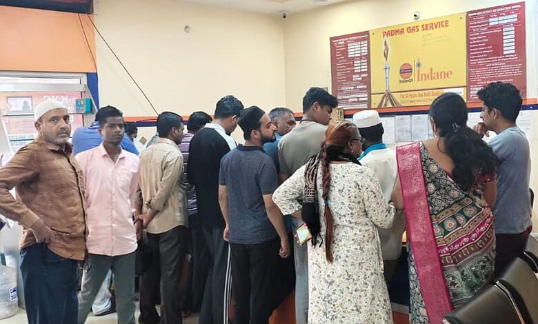 Crowd gathers at LPG booking counter amid rumours of shortage.