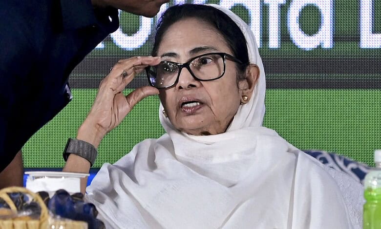 Mamata Banerjee adjusting her glasses at a political event, highlighting her active engagement in regiona.
