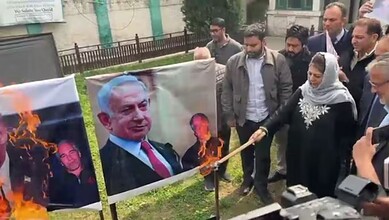 People protesting with images of political leaders and burning flags.