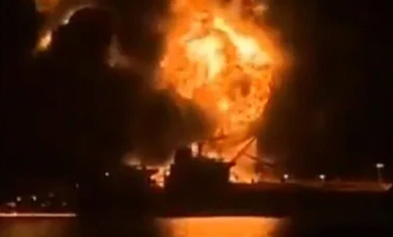 Oil tanker on fire after attack at sea, with large flames and thick black smoke rising.