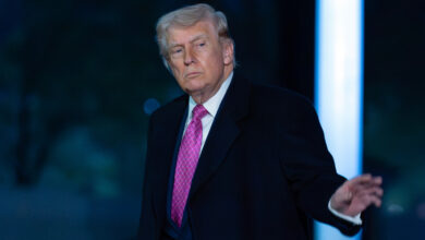 President Donald Trump waves to the media as he walks on the South Lawn upon his arrival to the White House.