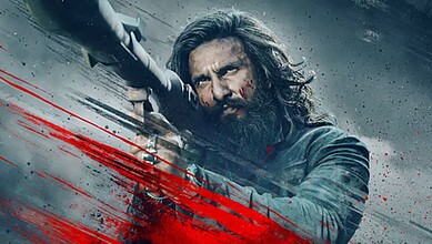 An intense scene from Dhurandhar 2 showing a fierce character aiming a weapon, highlighting the film's hi.