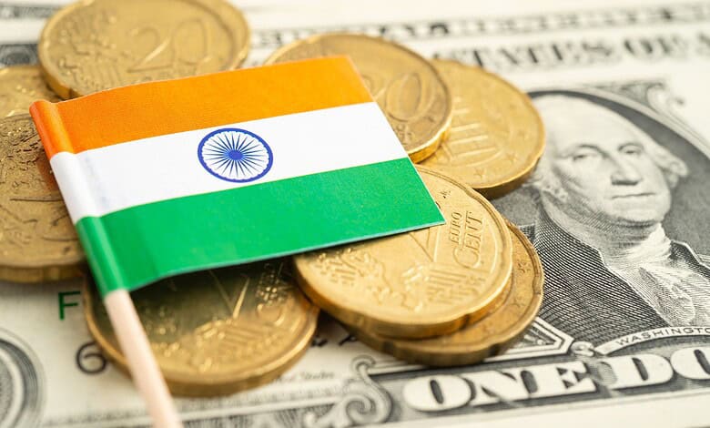 India flag on coins and dollar bills, illustrating currency exchange and economic fluctuations.