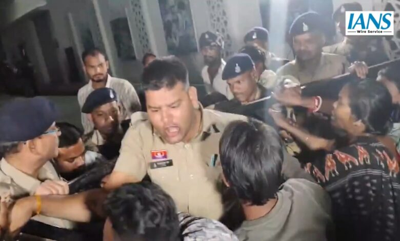 A police officer tries to control protestors outside the hospital