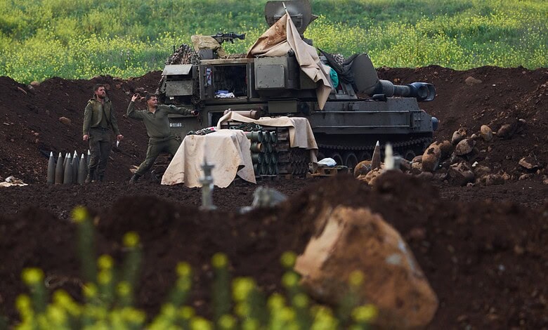 Military tank and soldiers in a field, with green grass and soil, possibly during a training or conflict.