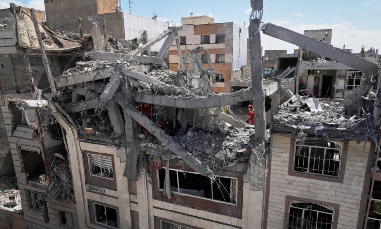 First responders inspect a residential building hit in an earlier US-Israeli strike in Tehran on Friday, March 27.