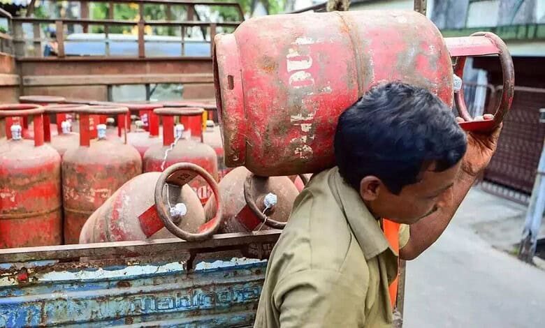 Gas cylinders stacked outdoors, man inspecting for safety or maintenance.