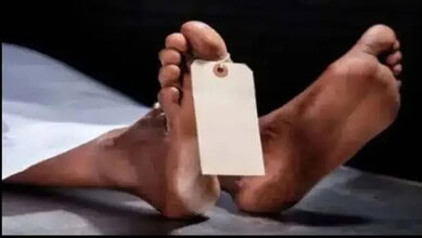 Hand holding a blank tag with feet in the background, related to Telangana murder case.