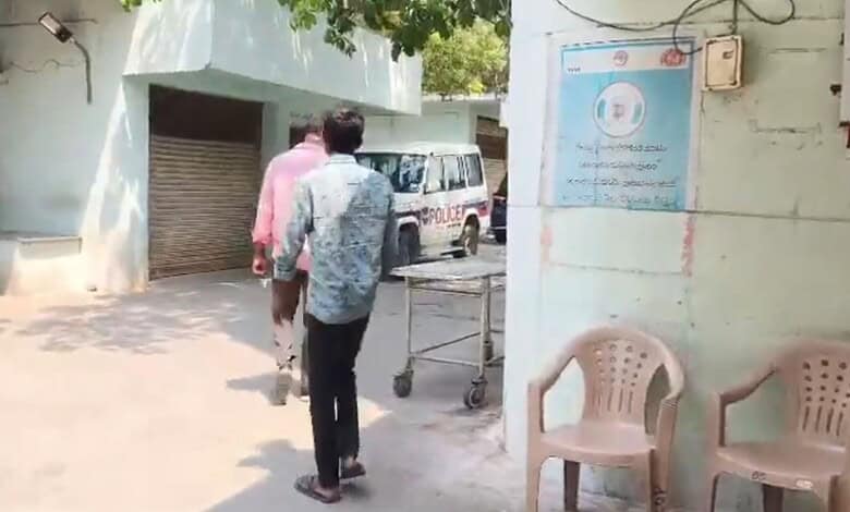 Man being detained outside a building in Hyderabad related to health and safety concerns.