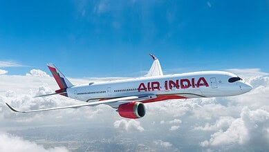 Air India aircraft flying above clouds, highlighting staff travel misuse investigation.