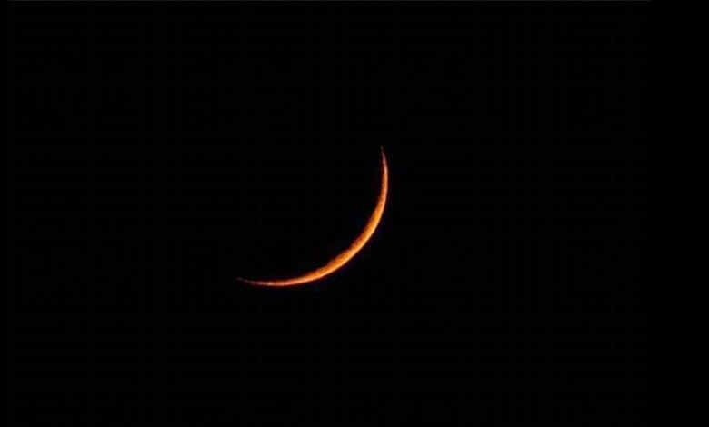 Crescent moon illuminated against a dark night sky, capturing a serene celestial scene.
