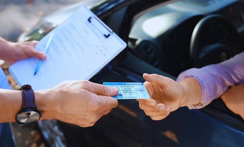 Police officer issuing a fine to a driver without a license during a traffic stop.