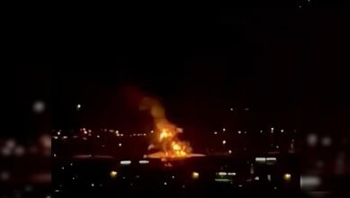 Fire at Dubai airport caused by drone strike, massive flames and smoke visible at night.