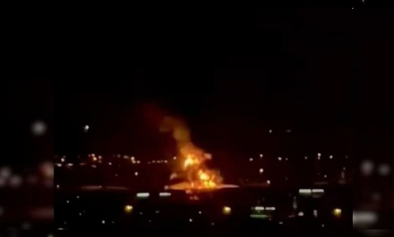 Fire at Dubai airport caused by drone strike, massive flames and smoke visible at night.