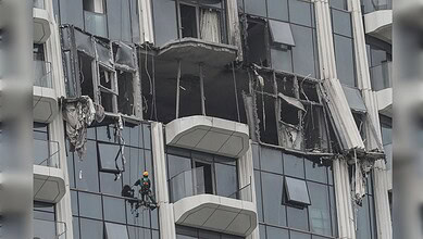 Damaged Dubai building with broken windows and debris after drone debris hit during regional conflict.
