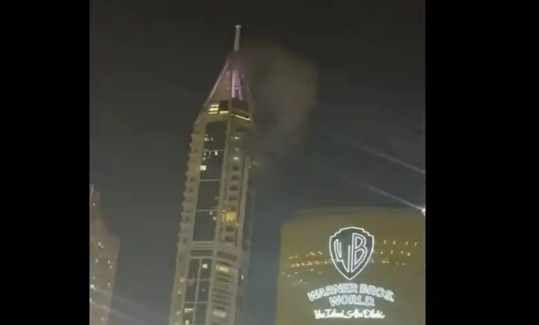 Night view of a tall building with smoke and bright lights during a conflict in Lebanon.