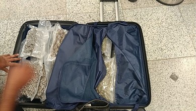 Luggage open with clothes and accessories packed inside, ready for travel.
