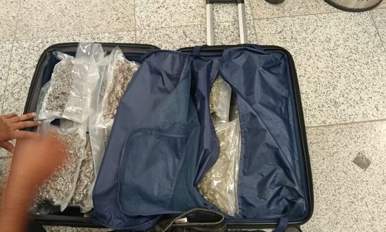 Luggage open with clothes and accessories packed inside, ready for travel.