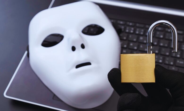 Image shows a mask on a laptop and an open lock