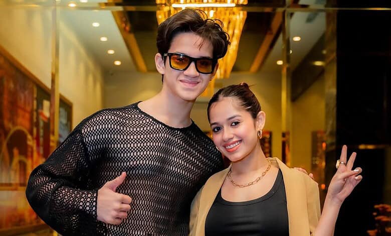 Jannat Zubair smiling and posing with peace sign at a public event.