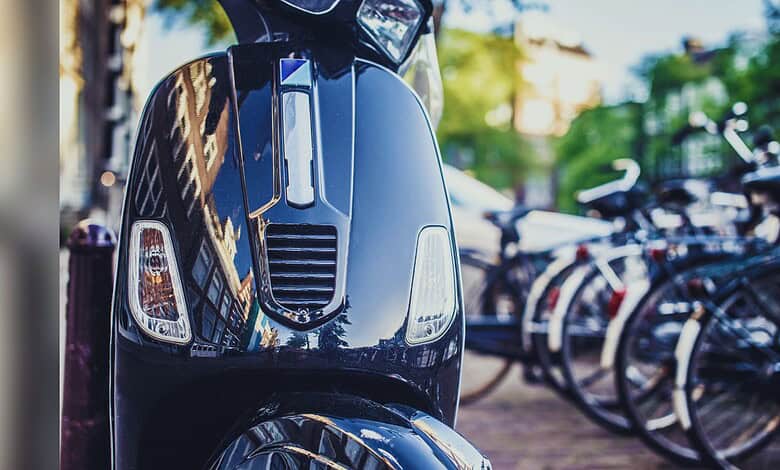 Motorcycle parked on street with bicycles in the background, reflecting urban environment and transportat.