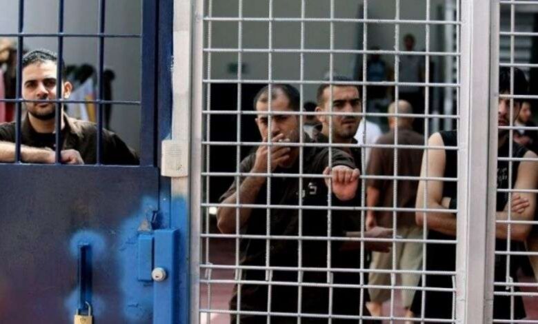 Palestinian prisoners seen behind metal bars inside a detention facility.